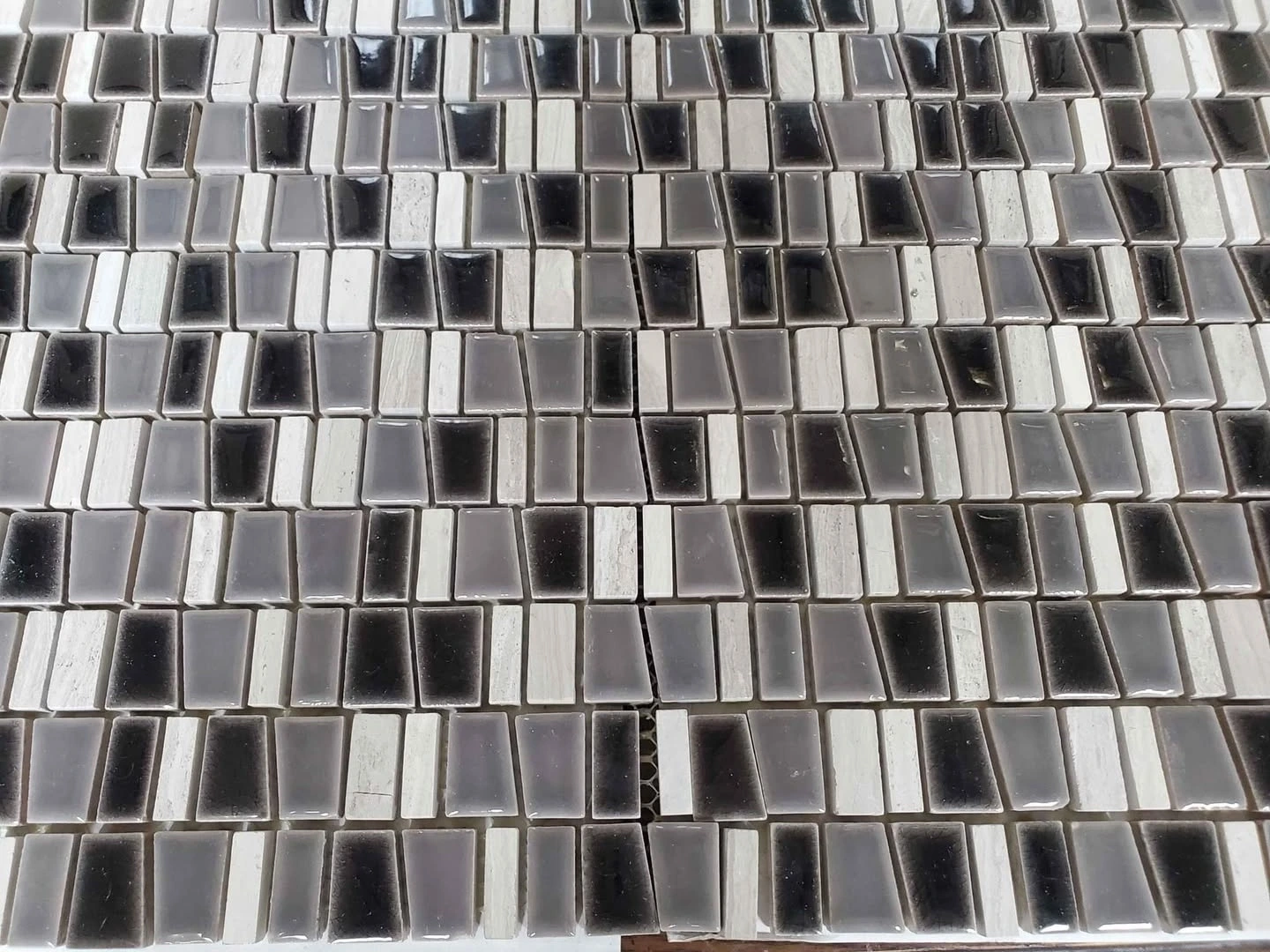 A photo of Black, white, and grey mosaic tile sheets